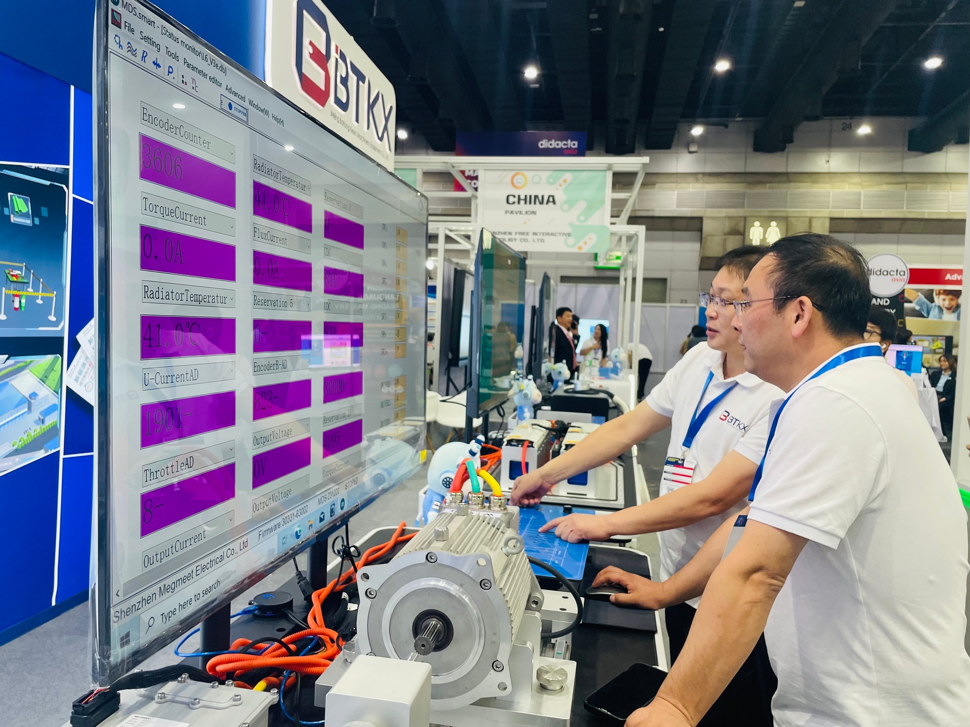 Technical visitors reviewing measurement data on BTKX equipment